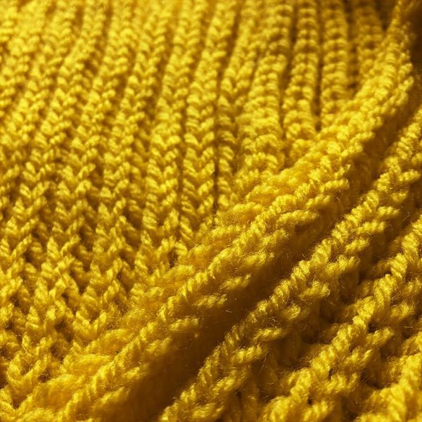 Detailaufnahme handgestrickter gelber oversize Schal. Bjarki