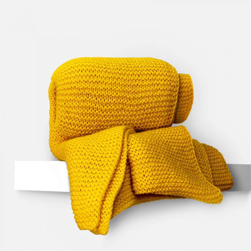 Produktfoto gelber handgestrickter oversize Schal. Trym
