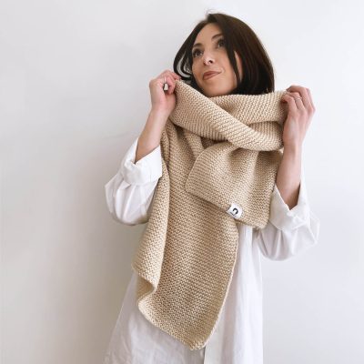 Modell mit handgestricktem beige farbendem oversize Schal. laerke