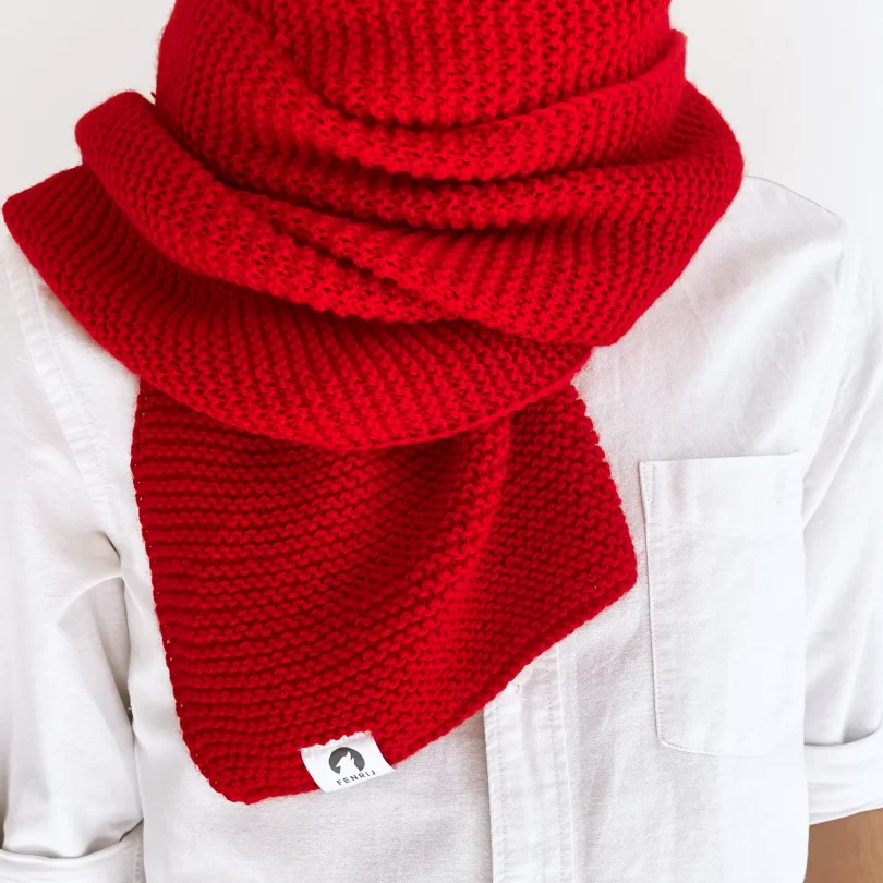 Modell mit handgestricktem rot farbenden oversize Schal. Rejk
